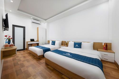 a bedroom with two beds and a television at LAN HA PEARL HOTEl in Phù Long