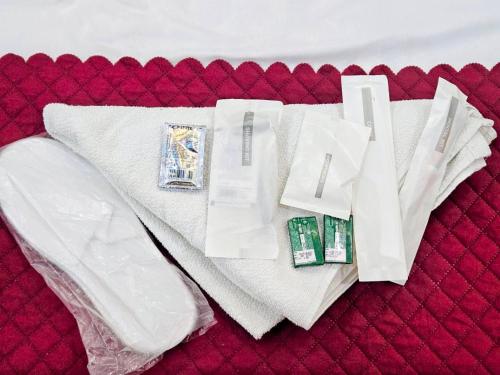 a pile of white towels on a red bed at Kharari Inn in Ayodhya
