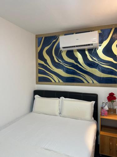 a bedroom with a bed with a air conditioner on the wall at Hotel Blue Orchid in Bayan Lepas