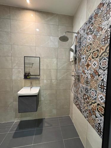a bathroom with a sink and a shower at Tdoze Hotel At Piccadilly Ipoh in Ipoh