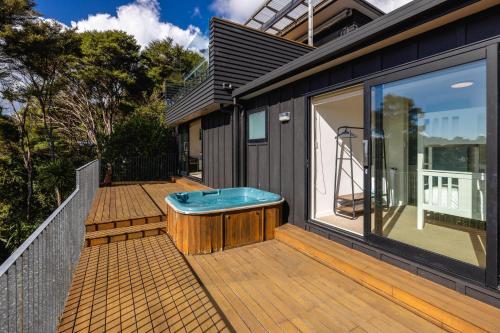 a hot tub sitting on the deck of a house at Hekerua Heights with Hot Tub and Seaviews in Oneroa