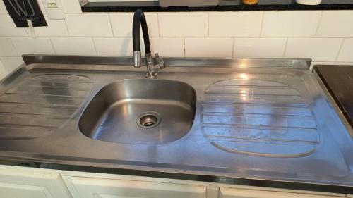 a stainless steel kitchen sink with a faucet at Casa Goiaba in Piçarras