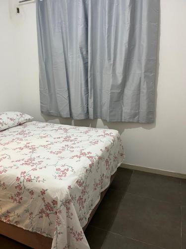 a bedroom with a bed and a window with a sheet at Casa Goiaba in Piçarras
