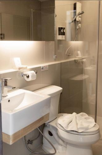 a bathroom with a sink and a toilet and a mirror at The 28th Hotel in Kanchanaburi City