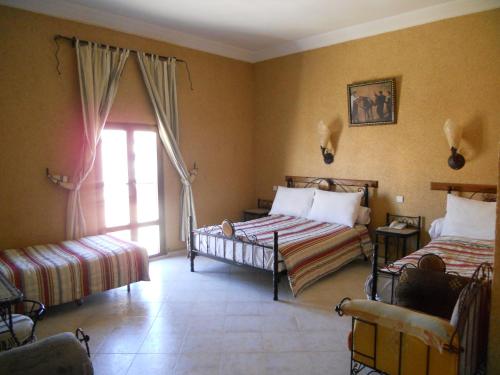 a bedroom with two beds and a window at Hotel Salama STE SAL- AMA SUD SARL AU in Tafraout