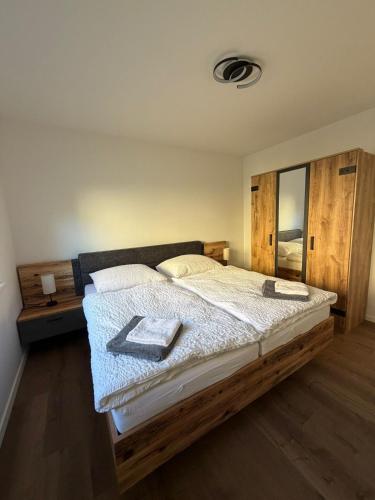 a bedroom with a large bed with a wooden headboard at Pollross Apartments in Reichenau