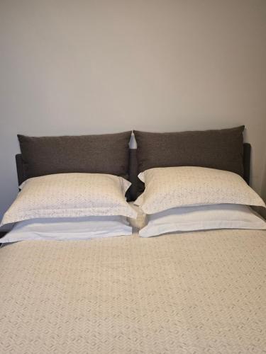 a bed with two pillows on top of it at Rosewood Podgorica in Podgorica