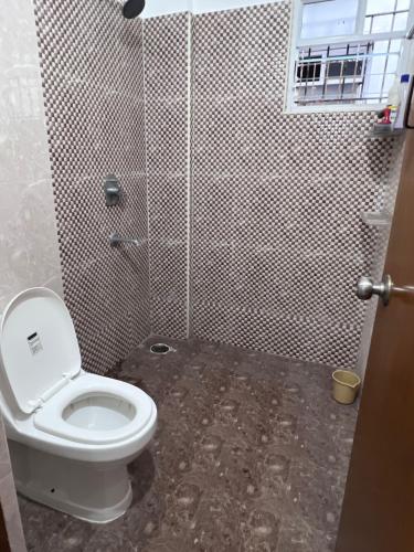 a bathroom with a toilet and a shower stall at shankara stays in Bangalore