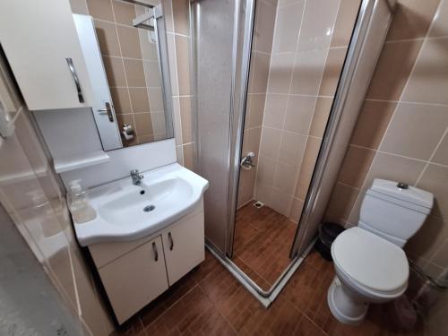 a bathroom with a shower and a toilet and a sink at Dilmac Hotel in Gelibolu