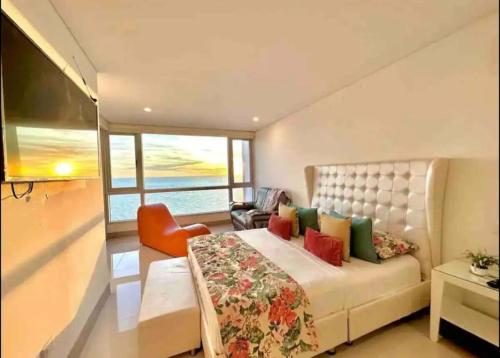a bedroom with a large bed and an orange chair at Large 3BR Apt with beautiful ocean views in Cartagena de Indias