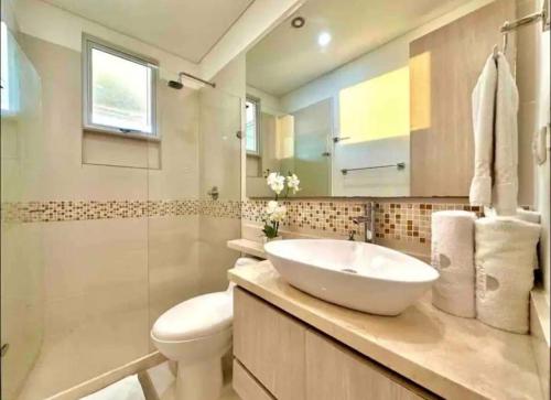 a bathroom with a sink and a toilet and a mirror at Large 3BR Apt with beautiful ocean views in Cartagena de Indias