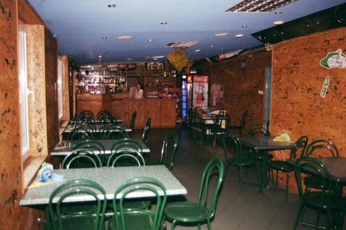 ザニエミシルにあるOśrodek Niezamyślの緑の椅子とテーブルのあるレストランのダイニングルーム