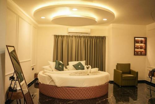 a bedroom with a large bed and a chair at The Mansion Resort And Spa in Panchgani