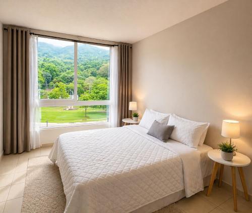 a bedroom with a white bed and a large window at Apto Deluxe, 3 hab, piscina y rooftop en Escalón in San Salvador