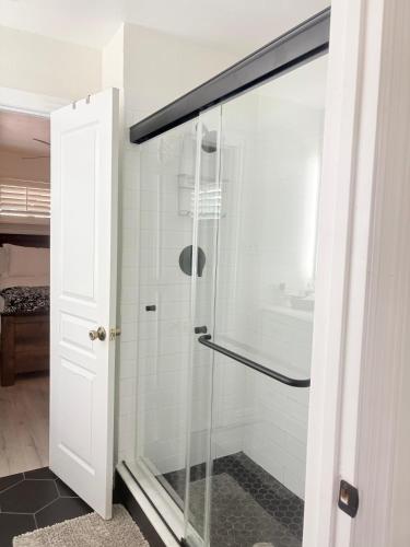a shower with a glass door in a bathroom at Casa Blanca in Irving