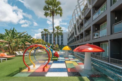 a pool with a playground with a colorful slide at Sugar Marina Hotel - ART - Karon Beach in Karon Beach