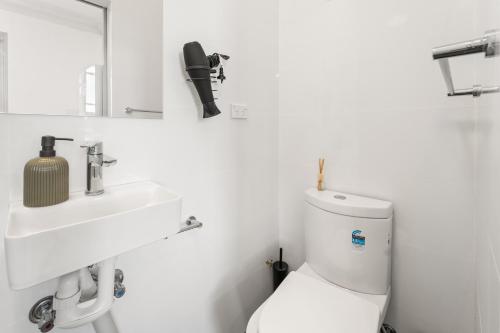 a white bathroom with a toilet and a sink at Olympic Paddington Budget Hotel - across Allianz Stadium in Sydney