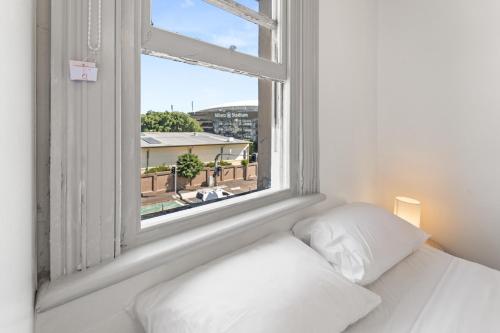 a bedroom with a bed and a large window at Olympic Paddington Budget Hotel - across Allianz Stadium in Sydney