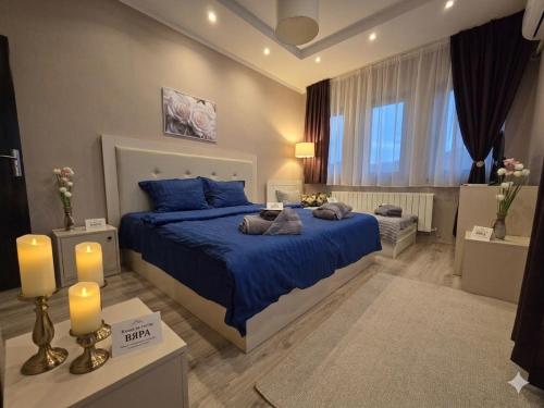 a bedroom with a large blue bed with blue pillows at "Бадевски рай" Къща за гости ВЯРА in Elena