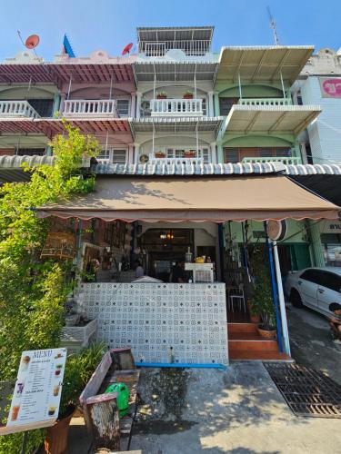 a building with an awning in front of it at Papa house red room in Pak Kret