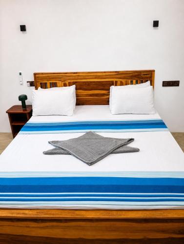 a bed with blue and white sheets and towels on it at New Happy bay in Arugam Bay