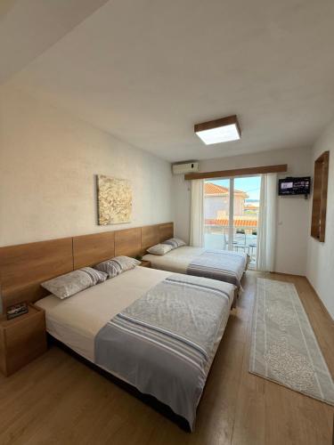 a bedroom with three beds and a window at Ajan Apartments in Ulcinj
