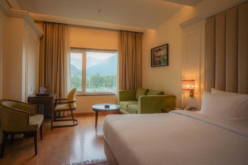 a hotel room with a bed and a window at Sarovar Premiere Srinagar in Srinagar