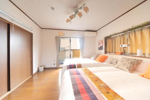 a bedroom with two beds and a couch at Coucou! in Takasaki