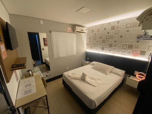 a bedroom with a bed with a teddy bear on it at Smart Hotel Joinville in Joinville