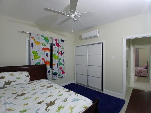 a bedroom with a bed and a ceiling fan at The Cosy Home in Lucea