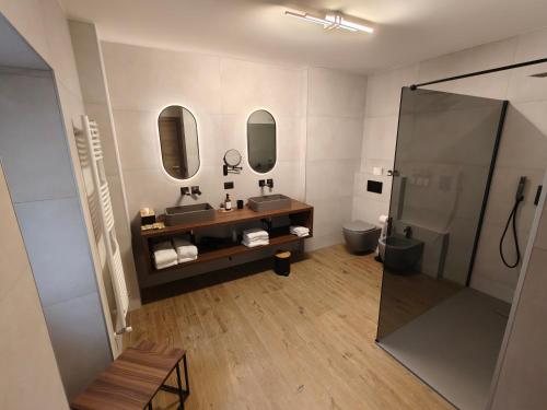 a bathroom with a shower and a sink and mirrors at Hotel Emiliana in Villadossola