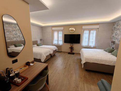 a hotel room with two beds and a mirror at Hotel Emiliana in Villadossola