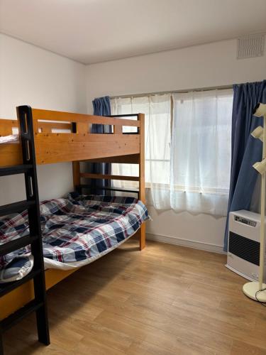 ein Schlafzimmer mit einem Etagenbett und einem Fenster in der Unterkunft TomoHouse in Kutchan