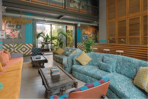 a living room with two blue couches and a table at Sugar Marina Hotel-SURF-Kata Beach in Kata Beach