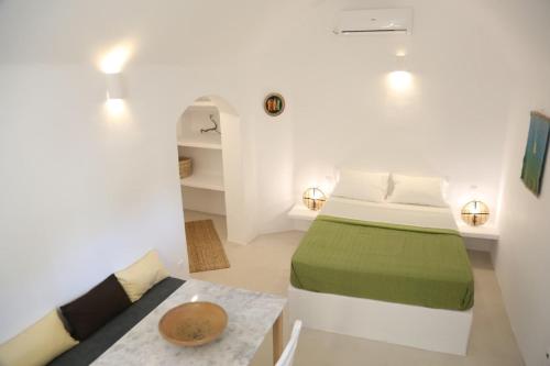 a white room with a bed and a table at Vasiliki guesthouse in Aroniadika