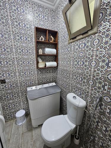 a bathroom with a toilet and a sink and a mirror at Pearl studio avec terrasse in Larache