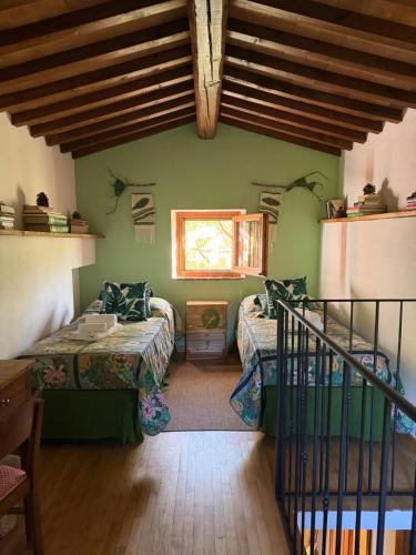 a room with two beds and a window at Casa nel bosco il Grottone in Montaione
