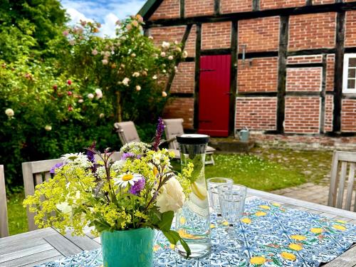 a table with a vase of flowers on top of it at Gut Petersdorf Lensahn - ideal für Familien und Hunde - mit Kamin, Parkblick, Terrasse, eingezäuntem Garten und E-Ladestation in Lensahn