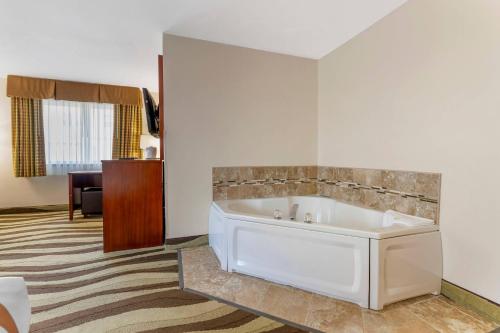 a bathroom with a bath tub in a room at Quality Inn & Suites Stoughton - Madison South in Stoughton