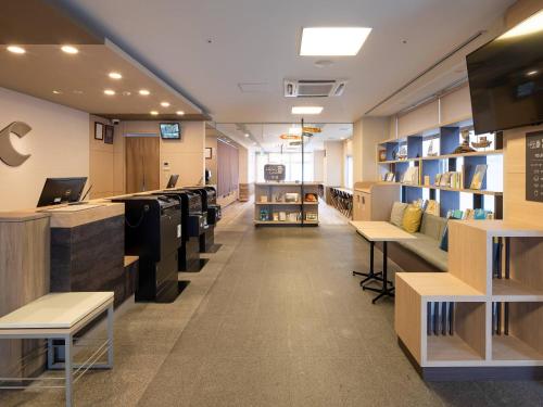 a library with tables and shelves in a store at Comfort Hotel Kure in Kure