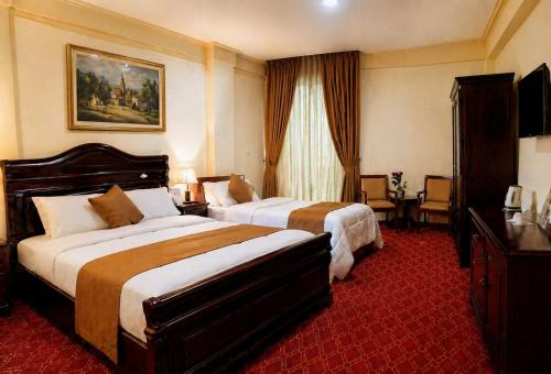 a hotel room with two beds and a television at Keba Guest House - Addis Ababa in Addis Ababa