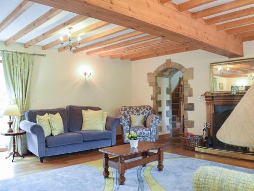 a living room with two couches and a table at Scarr House Farm in Muker