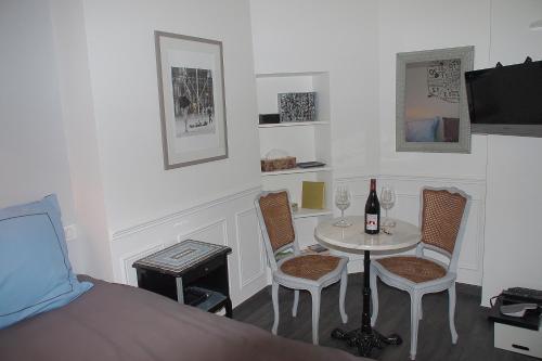 een slaapkamer met een tafel en stoelen en een bed bij Petit Paris - Oasis in Marais in Parijs