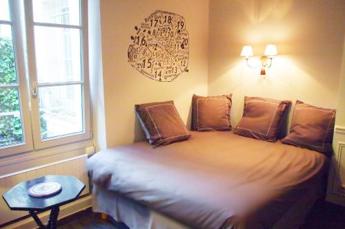 a bedroom with a bed with a table and a window at Petit Paris - Oasis in Marais in Paris