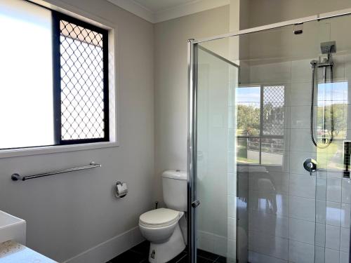 a bathroom with a toilet and a glass shower at 14A Convenient Ensuite Room in Coopers Plains in Brisbane