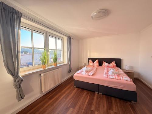 a bedroom with a bed with orange pillows and a window at Zwischen Donau & Kurpark in Bad Abbach