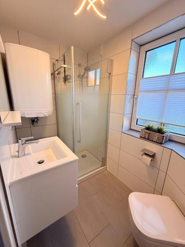 a white bathroom with a sink and a shower at Zwischen Donau & Kurpark in Bad Abbach