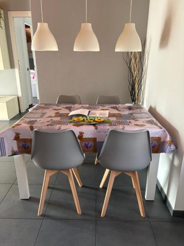 a dining room table with two chairs and a table with a tablecloth at River House in Porlezza