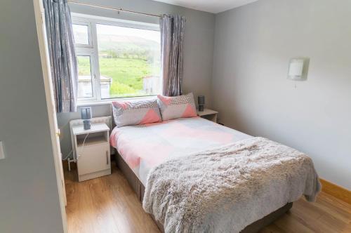 a small bedroom with a bed and a window at Beentee View - Cahersiveen in Cahersiveen