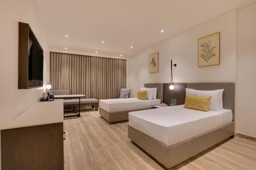 a hotel room with two beds and a television at Keys Select By Lemon Tree Hotels, Chirang in Bongaigaon
